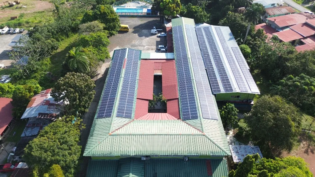 Paneles solares en las alas del campus, con la piscina al fondo